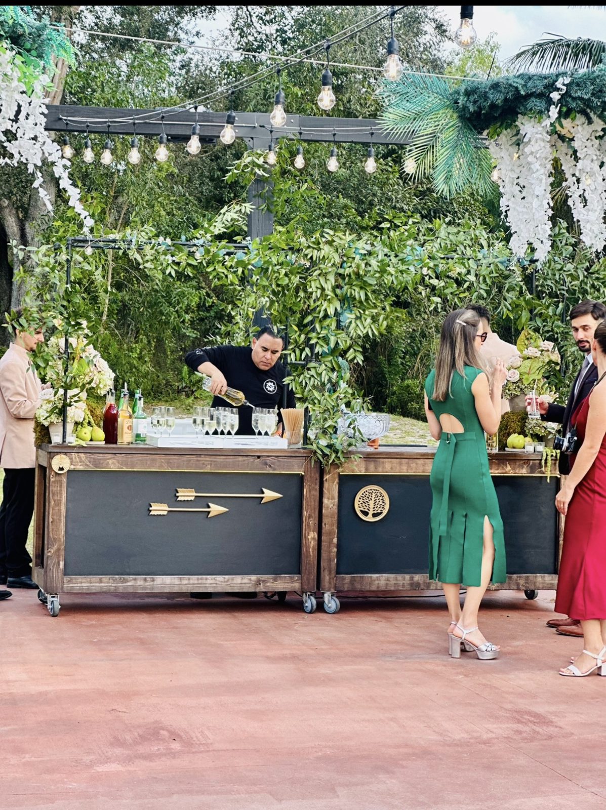 Guests and bartenders at the illuminated garden bar